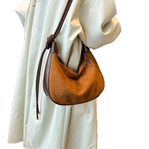 Sac croissant en daim marron avec fines bandoulières en corde et design minimaliste