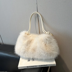 Sac à épaule chic en fausse fourrure crème avec bandoulière nouée sur présentoir épuré