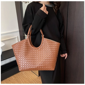 Macro shot of brown leather woven tote bag showcasing the intricate lattice craftsmanship