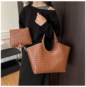 Close-up of caramel brown woven leather tote with matching inner pouch on model