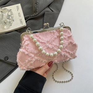 Pink denim shell bag with beaded pearl handle and frayed fringe texture crossbody style