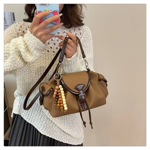Détail du sac seau en toile marron avec garniture en cuir et perles de bois ethniques