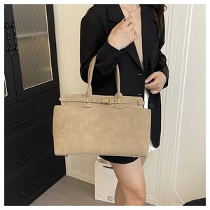 Detail view of large apricot suede tote bag with gold buckle and bottom studs