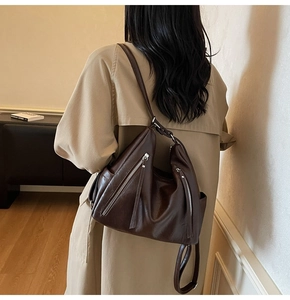 Model view of large dark brown leather tote bag with silver zippers and versatile straps