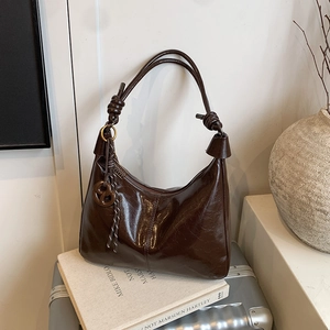 Glossy dark brown hobo bag with knotted strap and charm on books and silver luggage