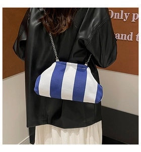 Détail du sac nuage tissé à rayures bleues et blanches avec chaîne en argent sur modèle
