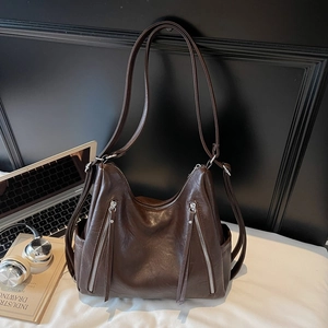Close-up of deep brown leather shoulder bag with functional dual metal front zippers