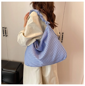 Detail of blue and white gingham tote bag with ruffled scrunchie shoulder strap design