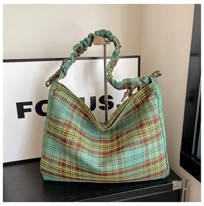 Detail of green plaid tote bag with pleated handles and drawstring cloud texture