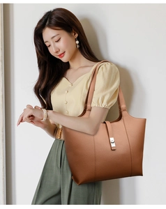 Brown tote bag with lychee texture and metal lock shown on a model for daily use