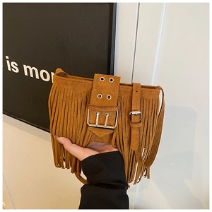 Détail d'un sac à bandoulière en suédine marron avec de longues franges et des boucles
