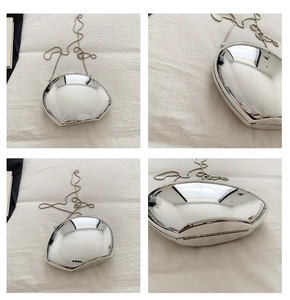 Silver mirror metal clutch bag in shell shape with chain strap and shiny reflective surface