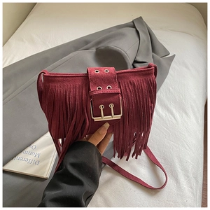 Détail du sac bandoulière bohème en daim bordeaux avec franges et boucle dorée chic