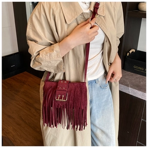 Détail du sac bandoulière bordeaux à franges avec boucles en métal et daim doux