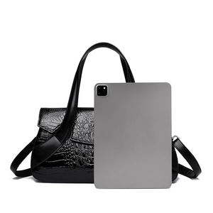 Detail of black crocodile texture bag showing capacity with tablet size comparison
