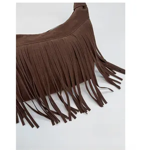 Detailed close-up of brown suede bag with dense long fringes and matte textured finish