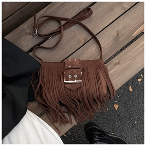 Détail du sac bandoulière en daim marron foncé avec de longues franges et boucles vintage
