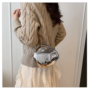 Close-up of a silver mirror irregular pebble-shaped clutch bag with a slim metal chain