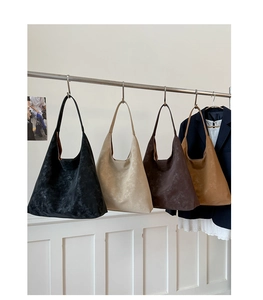 Minimalist vintage tote bags in four colors displayed on a rack with matte leather finish