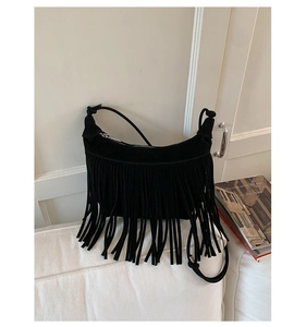 Detail of bohemian black suede shoulder bag with dense fringe and silver zipper