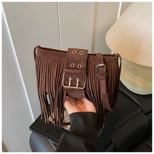 Détail d'un sac bohème en daim marron avec des franges et une boucle en métal vintage
