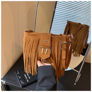 Détail du sac à bandoulière en daim marron avec franges vintage et sangle à boucle