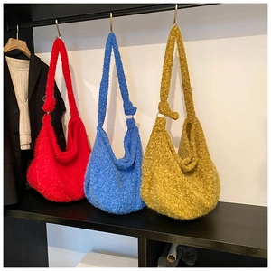 Detail of wool hobo bags in red, blue and yellow with metal rings and soft fuzzy texture