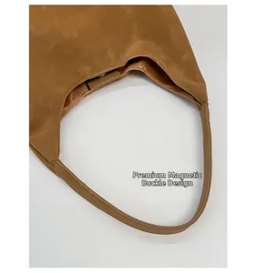 Detail of the high-quality magnetic buckle closure on a brown tote shoulder bag