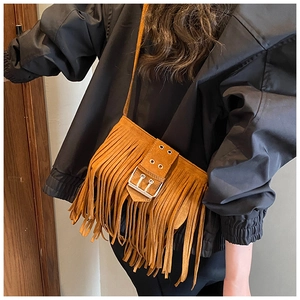 Détail du sac bandoulière en daim marron avec boucle rétro et éléments décoratifs à franges