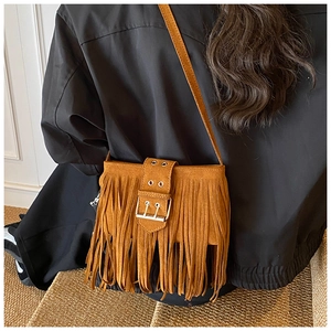 Sac bandoulière en daim marron avec franges bohèmes et boucle argentée sur modèle