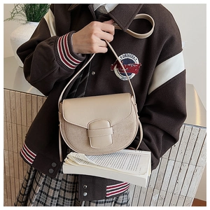 Detail of matte saddle bag featuring textured stitching and elegant clasp design