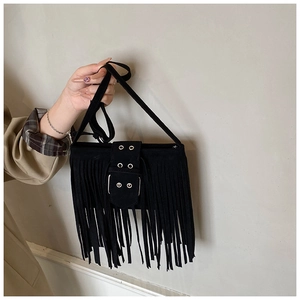 Détail du sac bandoulière à franges noires avec œillets métalliques et pompons rétro