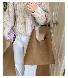 Hobo style brown suede shoulder bag showing large capacity and soft texture on model