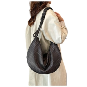 Dark gray checkered hobo bag with pleated strap shown from a side view on shoulder