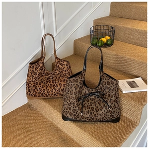 Detail view of leopard print tote bags with bow tie accents on natural stairs