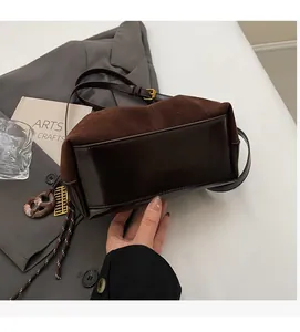 Detail of vintage dark brown bucket bag showing contrast of matte suede and smooth leather