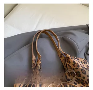 Detail view of the durable brown straps and leopard print pattern on the tote bag