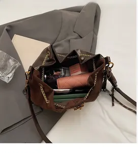 Detail of vintage brown bucket bag with chain drawstring showing spacious inner storage