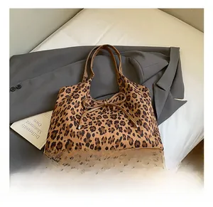 Close-up of leopard print tote bag featuring a leather bow and brown handle detail