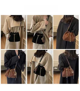 Close-up of retro matte bucket bags in black and brown with chain and pretzel charm
