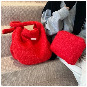 Detail of red fuzzy tote bag set with branded label and matching zipper pouch