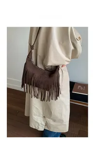 Detail of a brown suede crescent bag with long tassels and knotted shoulder strap