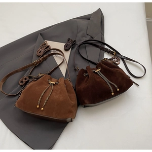 Detailed close-up of retro matte bucket bags with metal chain drawstrings and charms