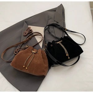 Detail of vintage matte bucket bags with gold chain drawstrings in black and dark brown