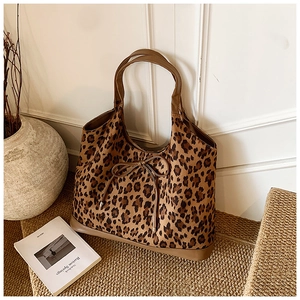 Detail showing leopard print tote bag with bow tie on vintage bench for daily commute