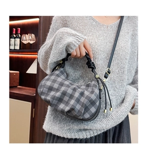 Detail of checkered cloud bag with pleated design and gold metal hardware accents