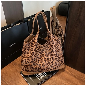Detail shot of leopard print tote bag with bow knot and stylish brown leather handles