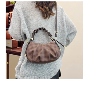 Detail of checkered cloud bag showing ruffled handle and adjustable metallic strap buckle