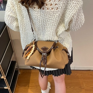 Vintage brown canvas crossbody bag with leather trim and wooden bead tassel detail