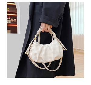 Detailed close-up of cream-white cloud bag featuring checkered texture and gold buckle
